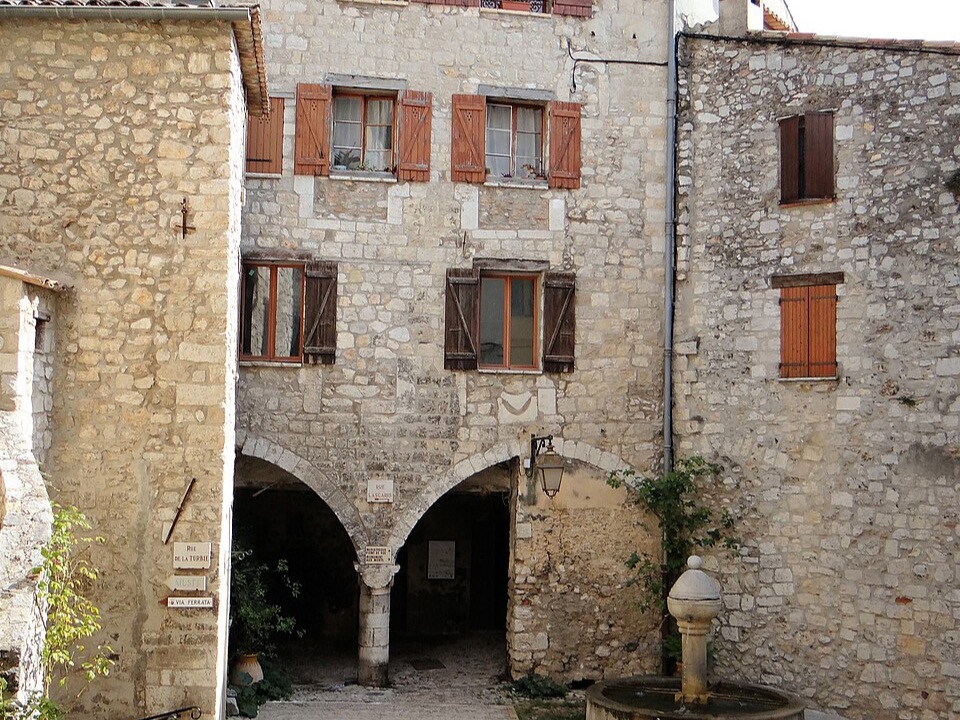 Old square in the village of Peille, with its fountain and arcades